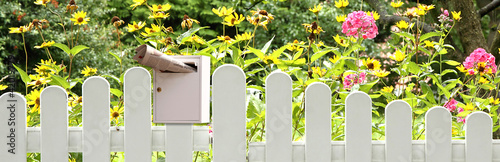 Gartenzaun mit Briefkasten und Zeitung