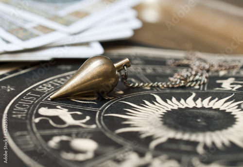 Pendel mit astrologischer Karte und Tarotkarten photo