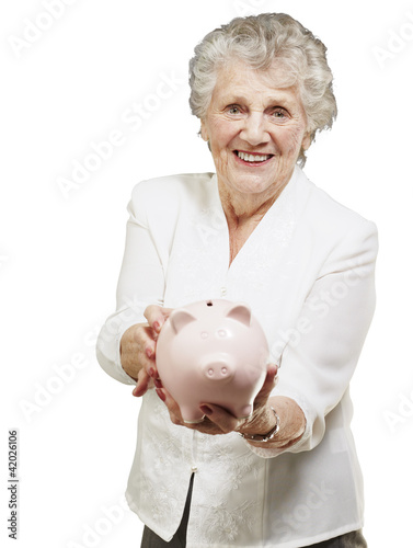portrait of senior woman showing a piggy bank over white backgro