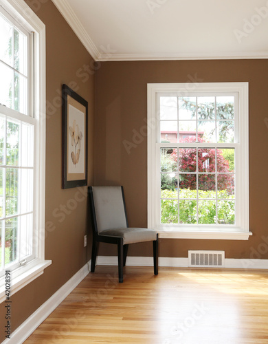 Living room corner with chair and two windows.