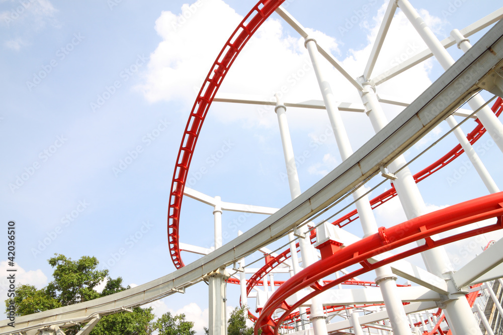 Curve of red and white roller coaster rail.