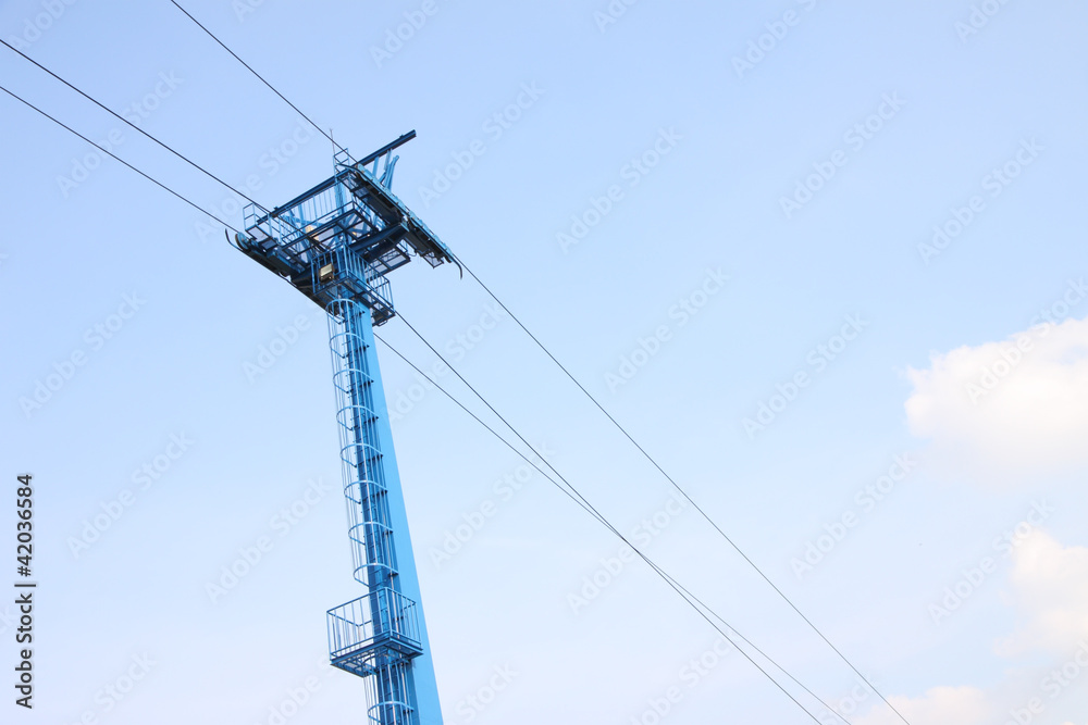 Blue pole of cable car in sky.