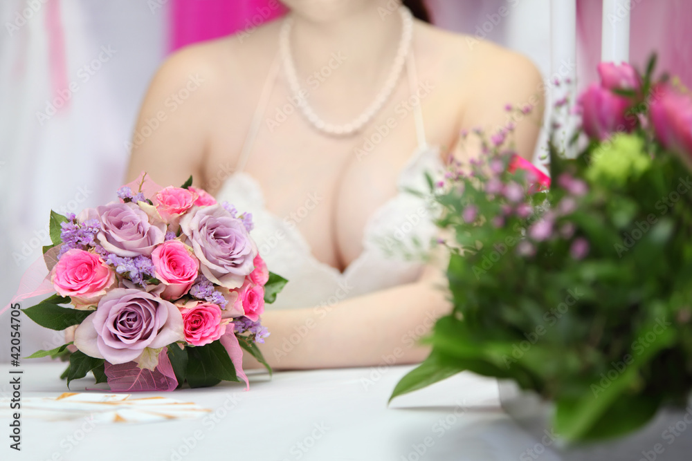 decollete of young bride, which sits at table with candles