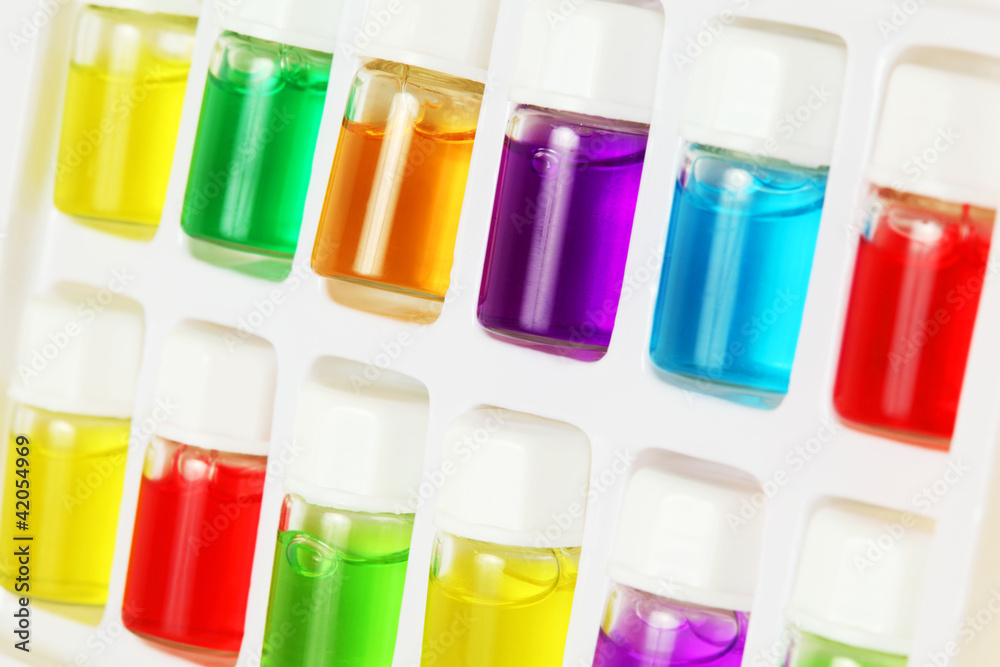 Twelve bottles of different colored aromatic oils Twelve bottles of different colored aromatic oils