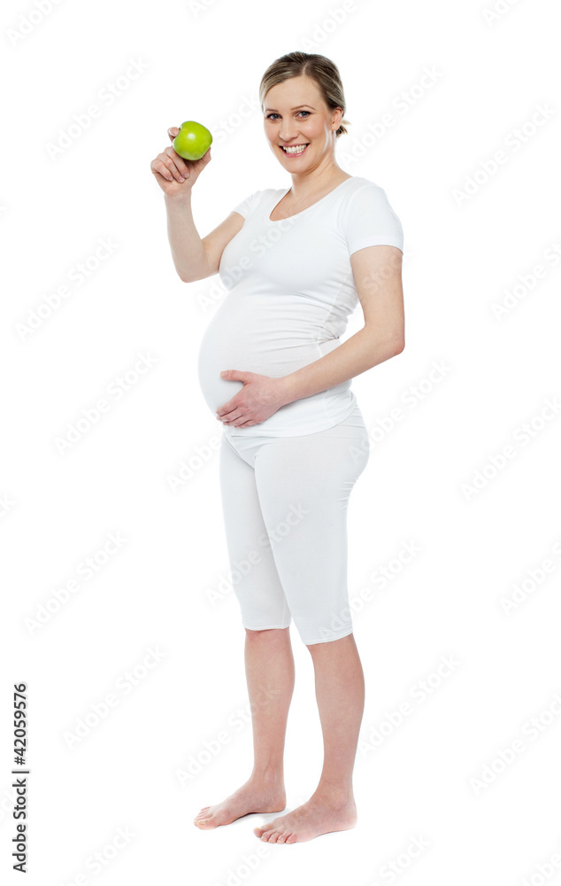 Pregnant woman showing fresh green apple Pregnant woman showing fresh green apple