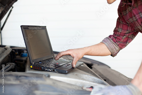 Car mechanic with laptop