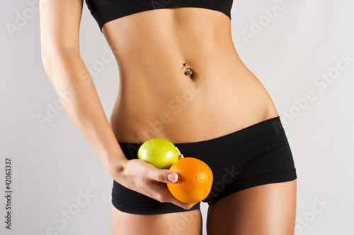 Concept of a healthy body. Thin belly, fruit