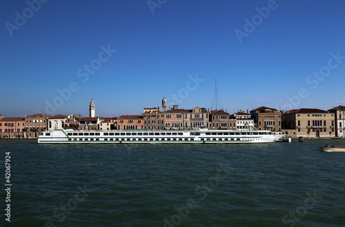 Long and narrow passenger ship moored in Venice