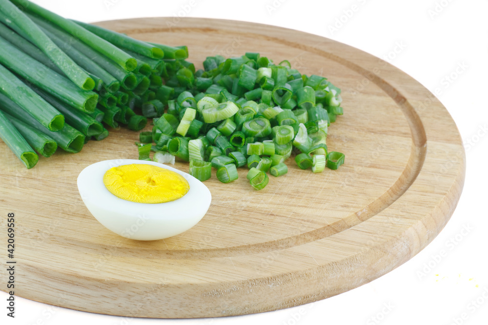 Green onions and half of the eggs on a wooden kitchen board Green onions and half of the eggs on a wooden kitchen board