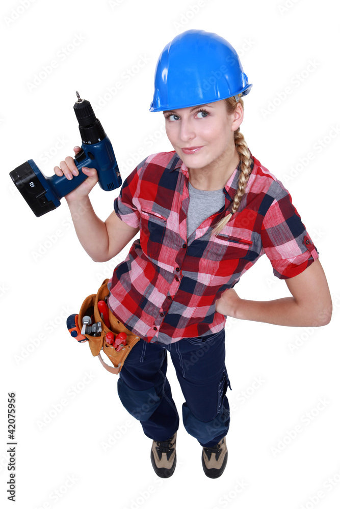 A female construction worker holding a drill. A female construction worker holding a drill.