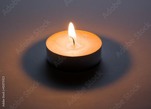 Lighted candle in dark