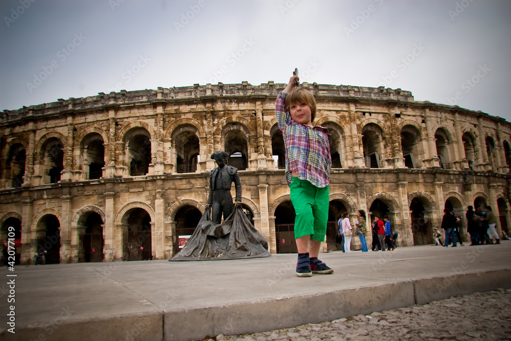 Enfant jouant devant les arènes de Nîmes
