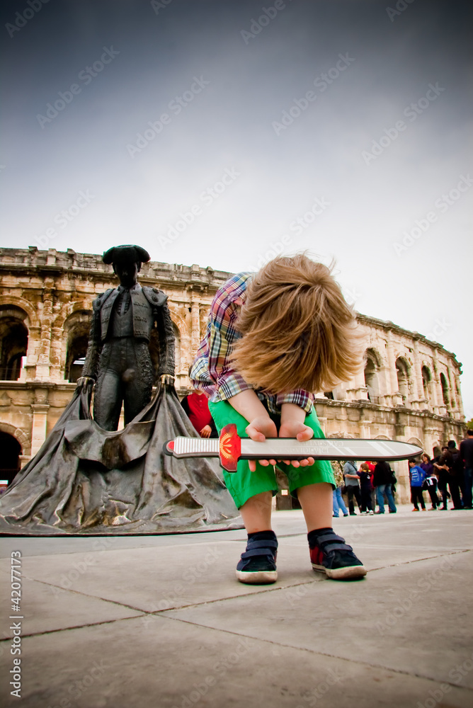 Enfant jouant devant les arènes de Nîmes