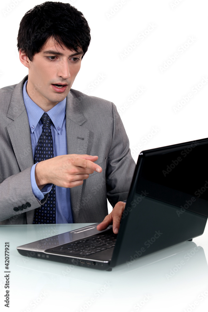 Surprised businessman pointing at his laptop Surprised businessman pointing at his laptop