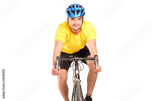 A smiling bicyclist with yellow shirt posing on a bicycle