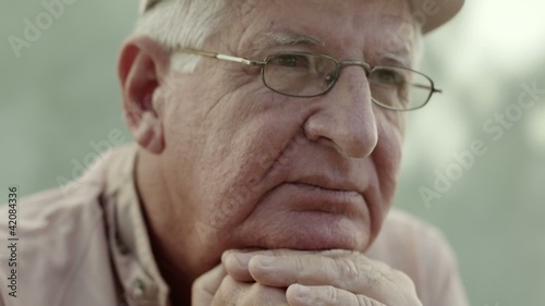 Portrait of serious old man with hat and eyeglasses