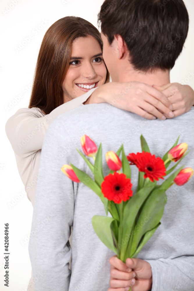 Man surprising his girlfriend with a bunch of flowers Man surprising his girlfriend with a bunch of flowers