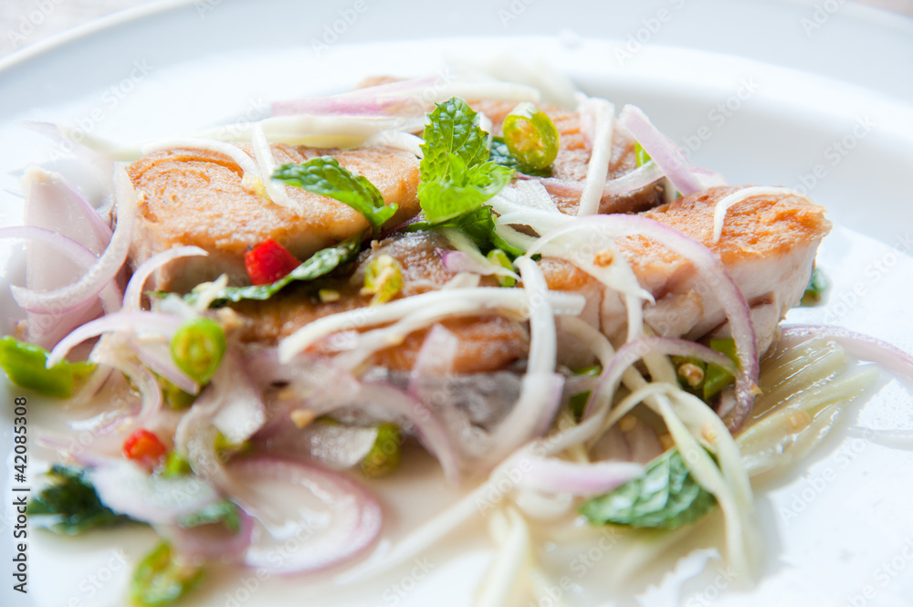 Spicy salad with fried fish and green herb in Thai style Spicy salad with fried fish and green herb in Thai style