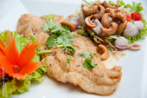 Deep fried fish serve with spicy salad and vegetables