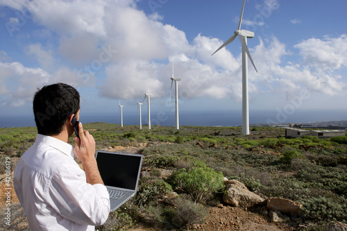 Man with a laptop at a windfarm