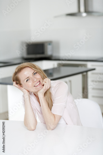 Young woman sat at a kitchen table