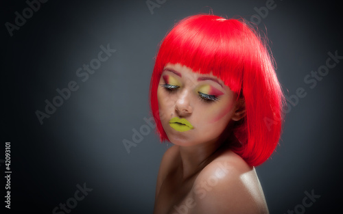 Cute young feamle with colourful makeup and red hair