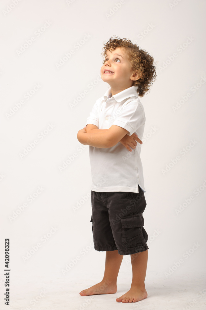 litle boy standing with his arms crossed looking up litle boy standing with his arms crossed looking up