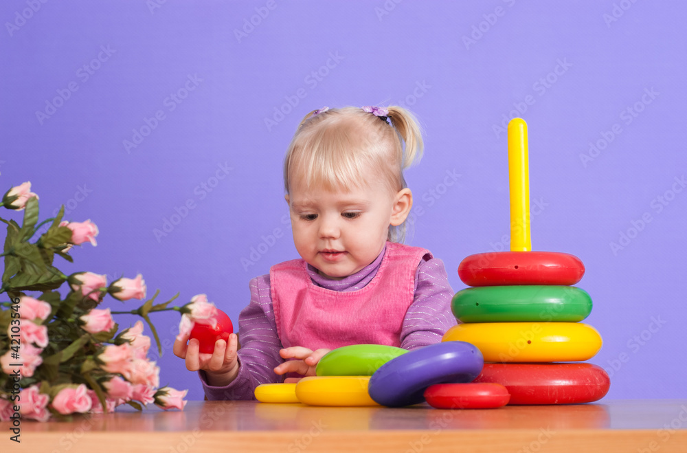 A small charming Caucasian poppet plays with toy A small charming Caucasian poppet plays with toy