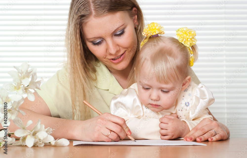 Beautiful Caucasian mummy and daughter sitting at a table