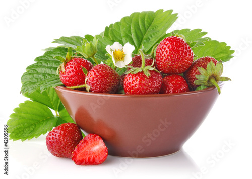 ripe strawberry in tureen with green leaves and flower