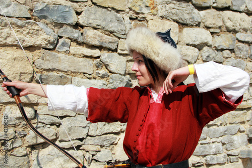 Beautiful young girl  with bow on castle wall photo