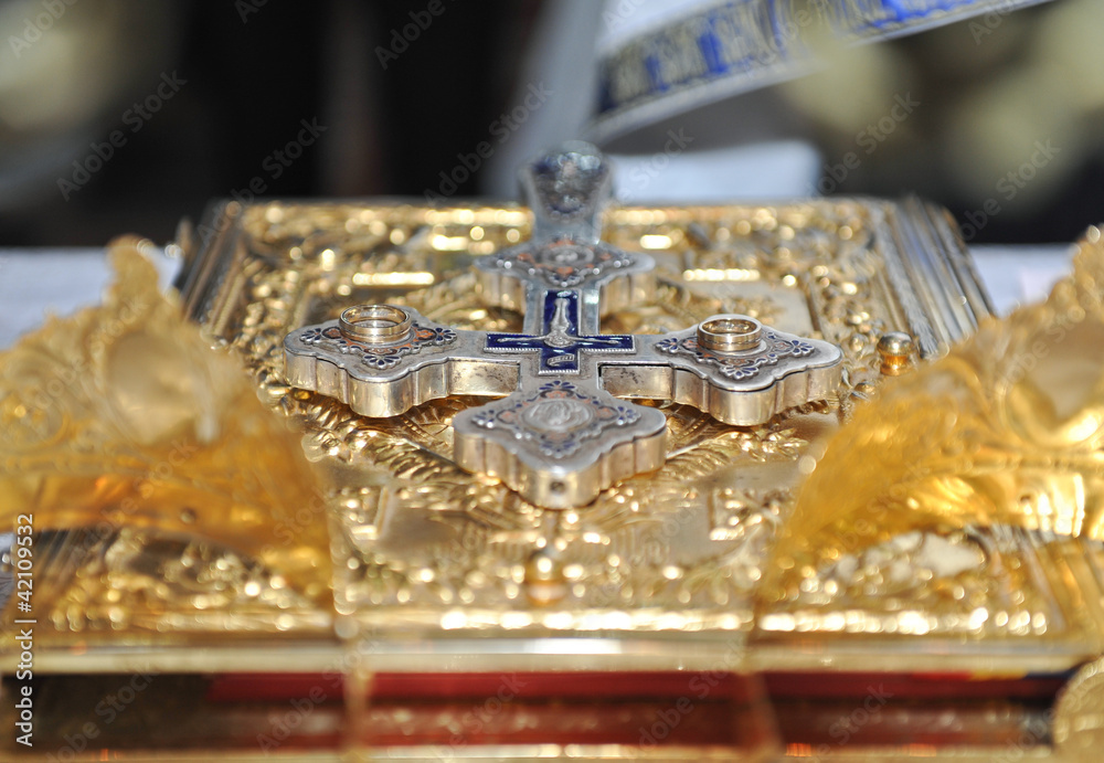 crosses , rings and crowns of gold on the table in church.