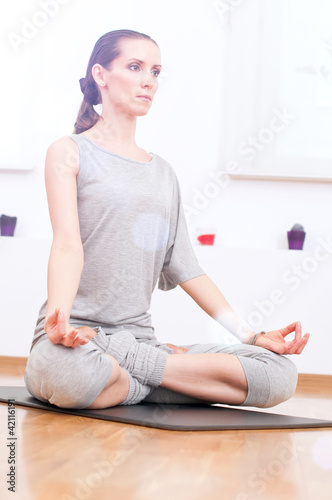 Woman doing stretching yoga exercise at sport gym