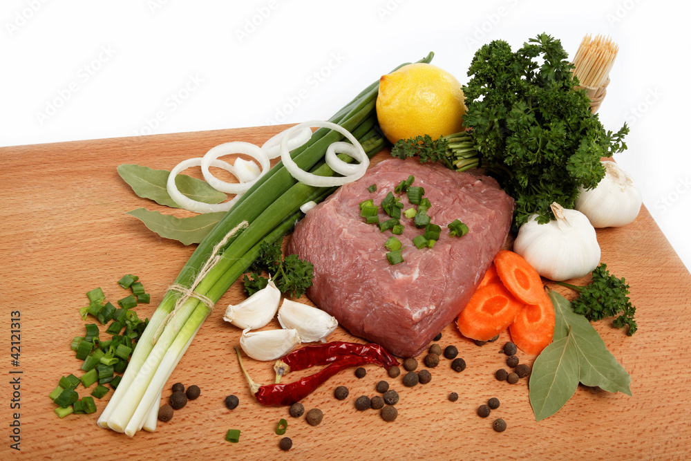 raw meat, vegetables and spices isolated on a wooden table. raw meat, vegetables and spices isolated on a wooden table.