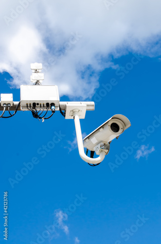 Surveillance camera on blue sky photo