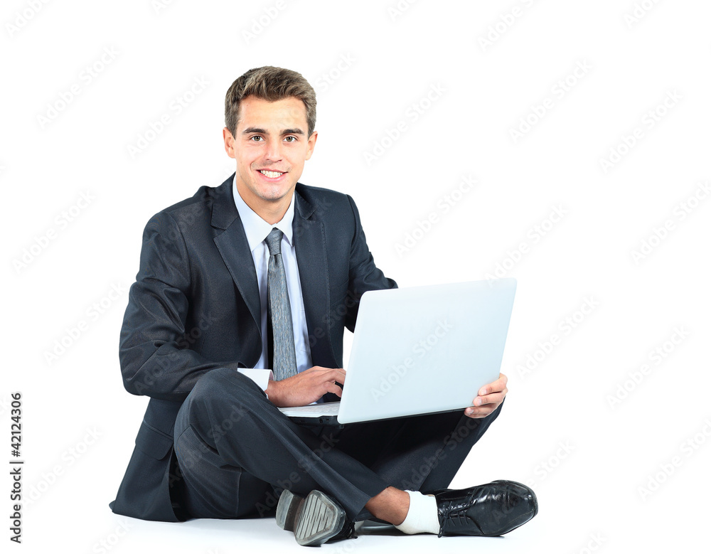 Isolated seated young businessman using a laptop Isolated seated young businessman using a laptop