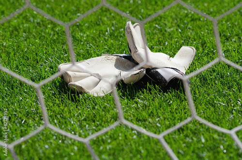 Goalkeeper gloves on the grass on the football field