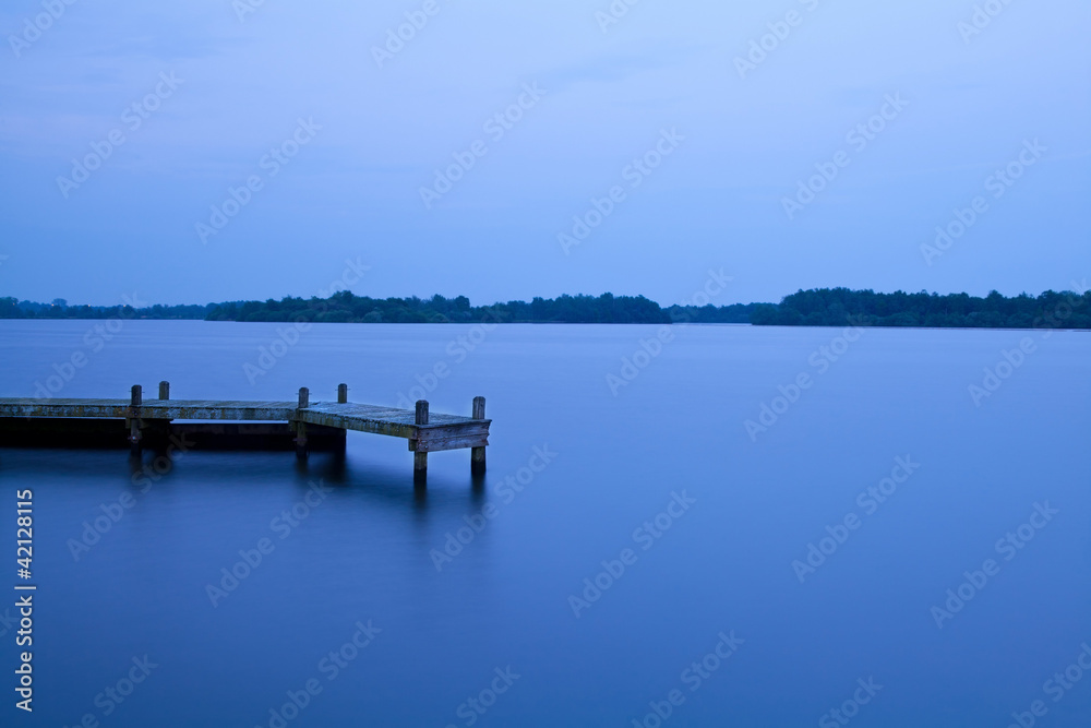 wooden pier on the lake at night