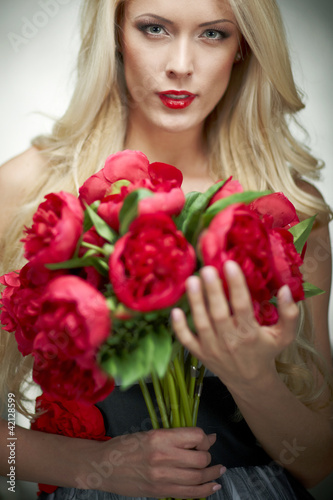 Closeup of fashion model posing with bunch of peonies