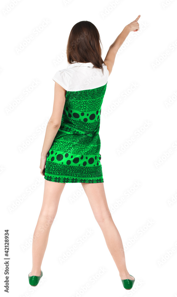 Fototapeta premium Back view of young brunette woman pointing at wall .