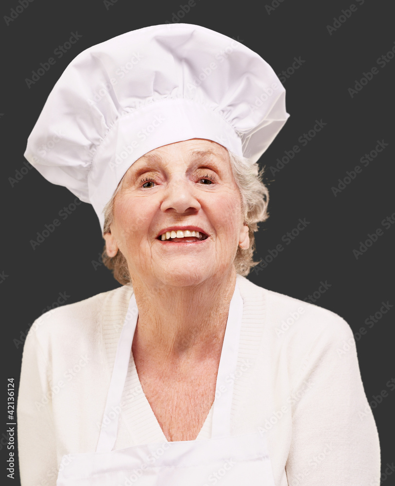 senior cook woman smiling over black background