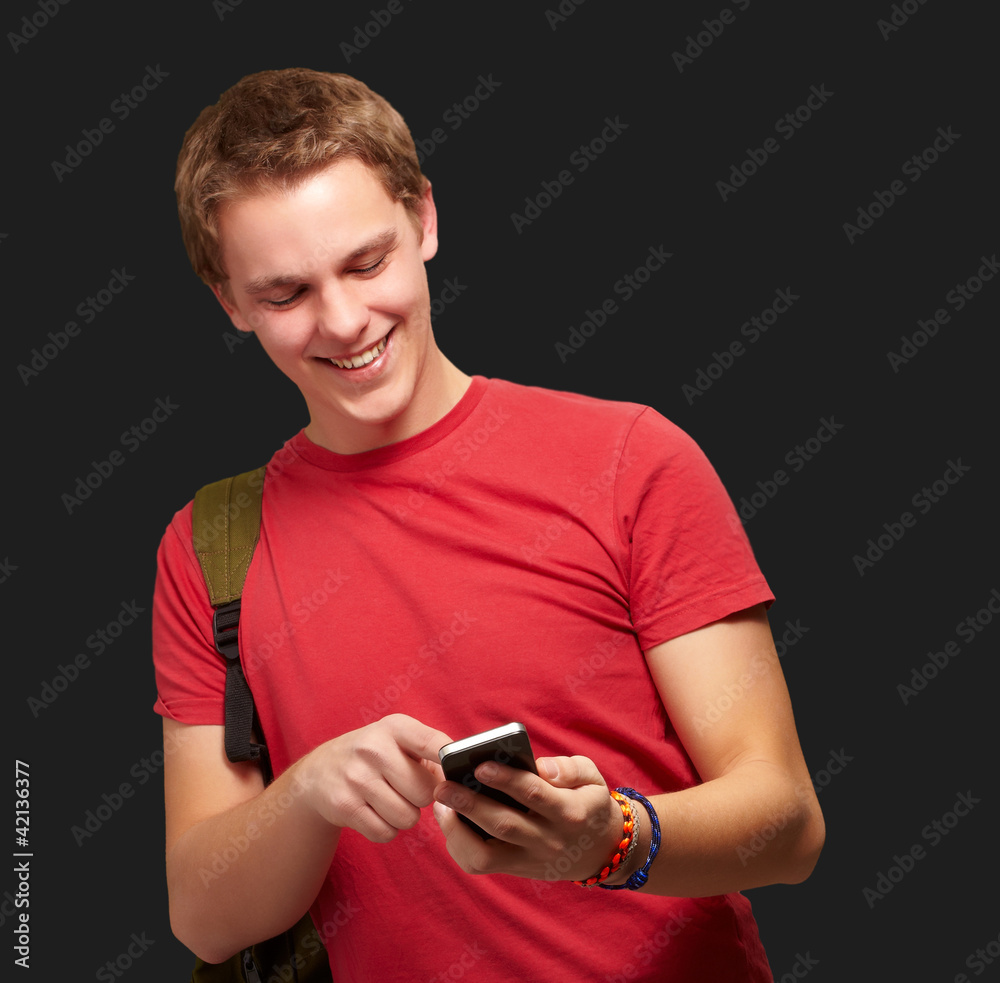 portrait of young man touching mobile screen over black backgrou portrait of young man touching mobile screen over black backgrou