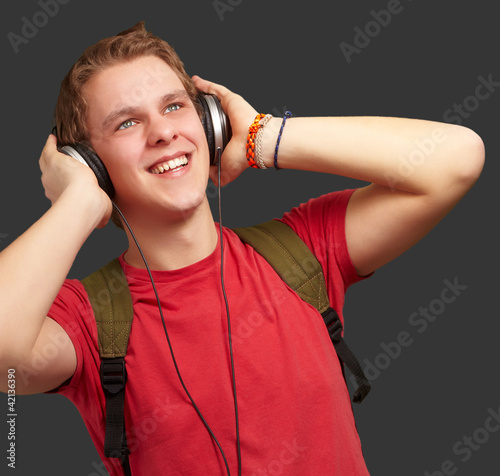 portrait of cheerful young student listening music with headphon photo