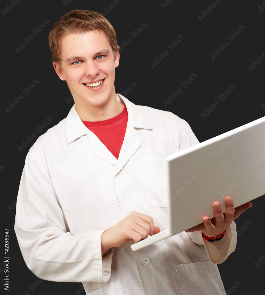portrait of young student holding laptop over black background portrait of young student holding laptop over black background