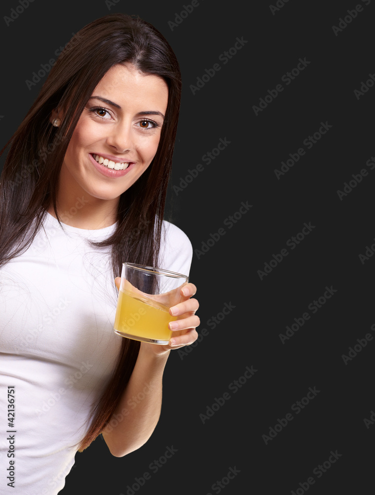 portrait of young girl drinking orange juice against a black bac portrait of young girl drinking orange juice against a black bac