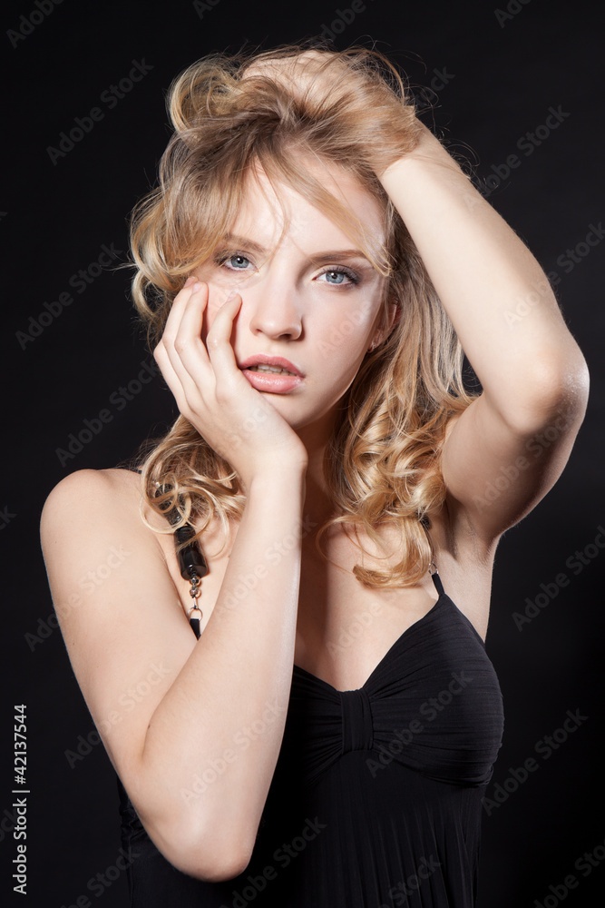 Glamorous young blonde woman in a black dress