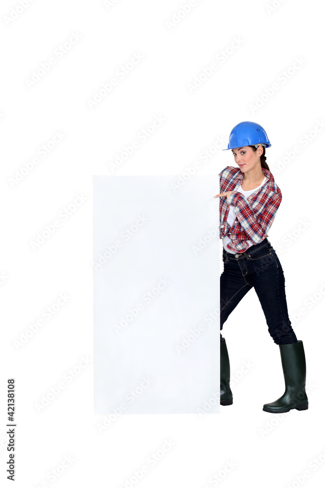 Female builder pointing at poster Female builder pointing at poster