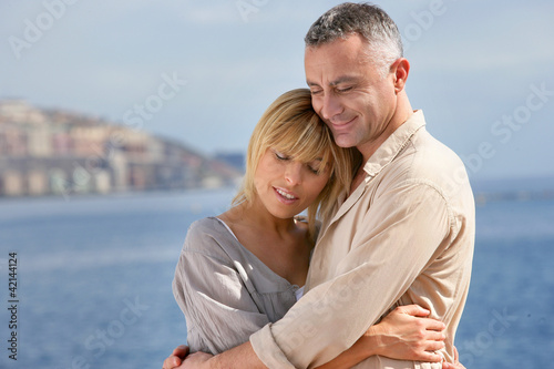 Couple hugging by the sea