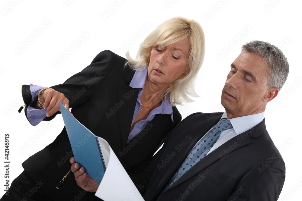 businessman and businesswoman reading a report businessman and businesswoman reading a report