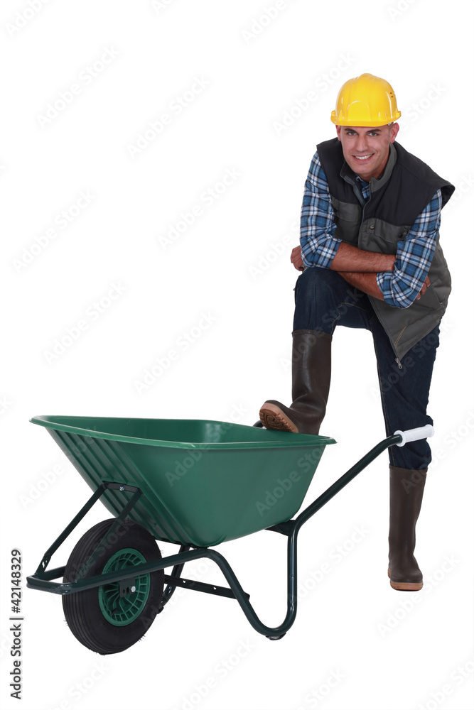 Tradesman with his foot propped on a wheelbarrow Tradesman with his foot propped on a wheelbarrow